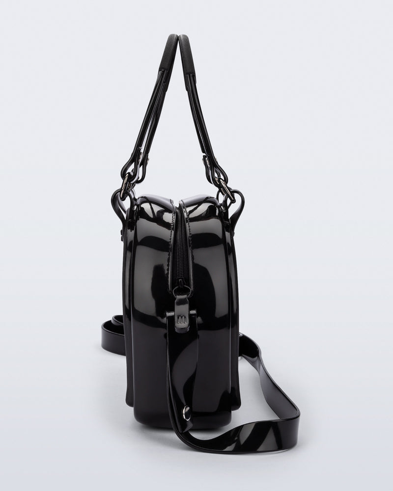 Side view of a black Bowling bag with handle strap and cross body strap