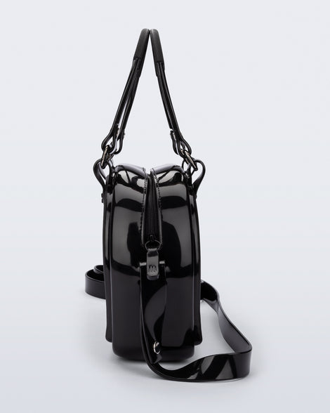 Side view of a black Bowling bag with handle strap and cross body strap