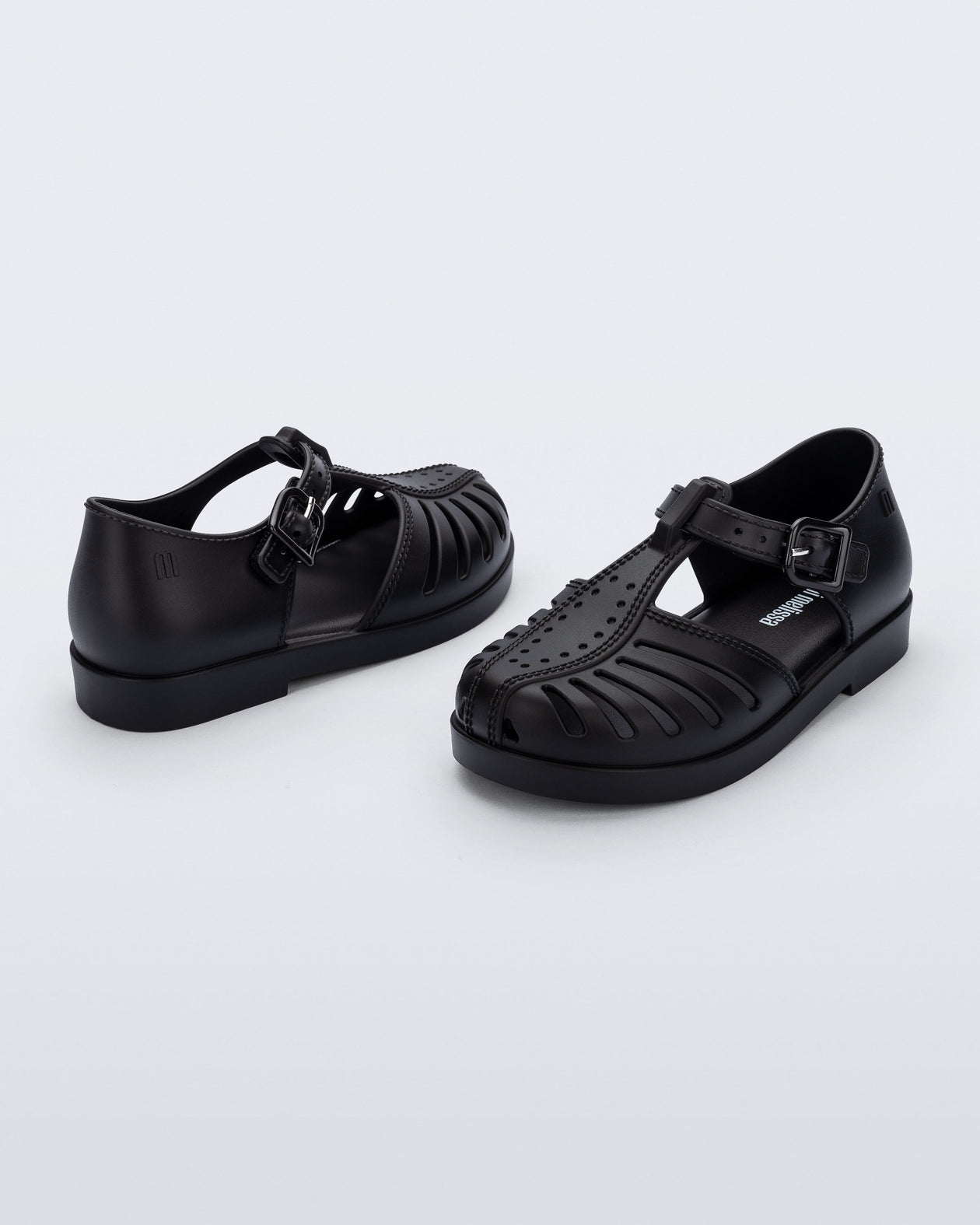 Side and angled view of a pair of black Aranha 79 baby flats with buckle
