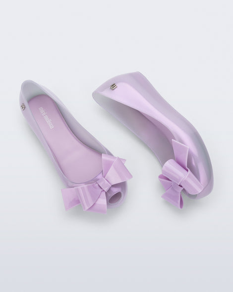 Side and top view of a pair of pearly lilac Ultragirl Classy kids flats with lilac bow