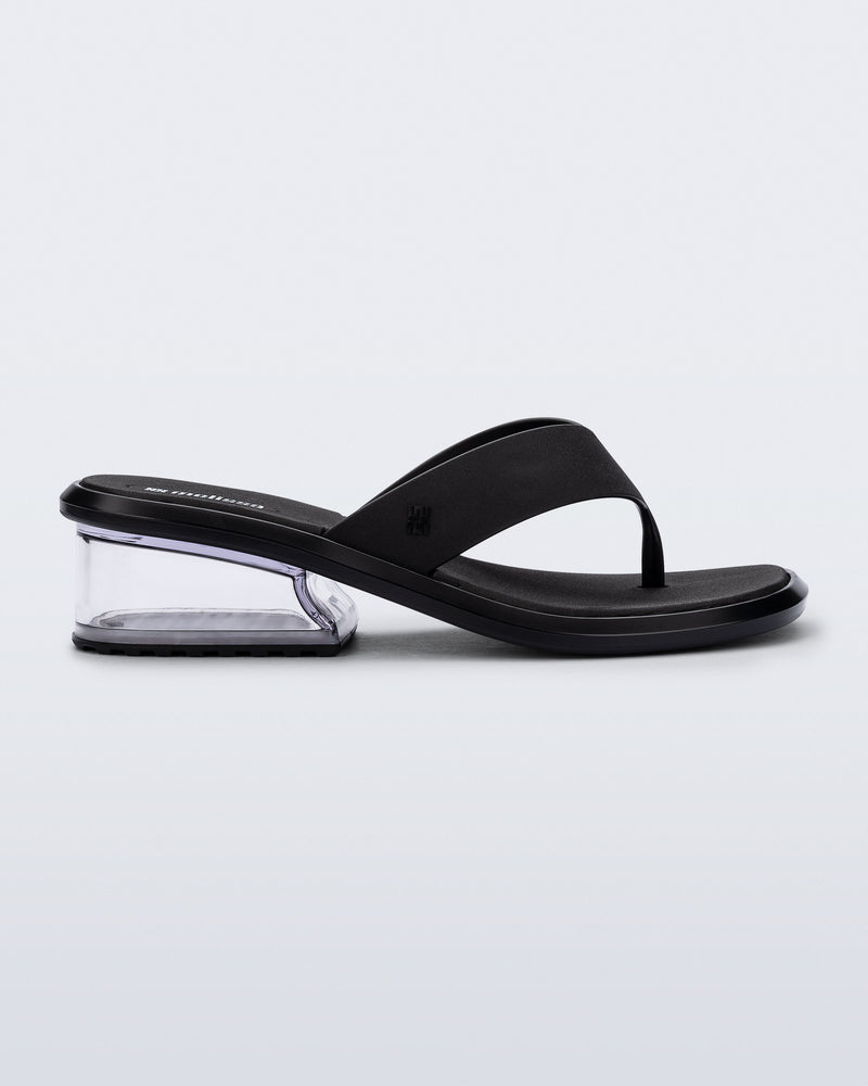 Side view of a black Margot flip flop with clear low heel 