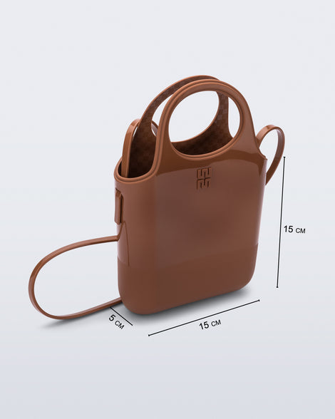 Angled view of a light brown Ultra Bag with handle and strap with bag dimensions of 15cm x 5cm x 15cm