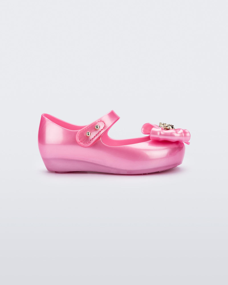 Side view of a pearly pink Ultragirl Princess ballerina baby flat with bow on top and silver details