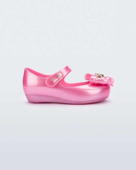 Side view of a pearly pink Ultragirl Princess ballerina baby flat with bow on top and silver details