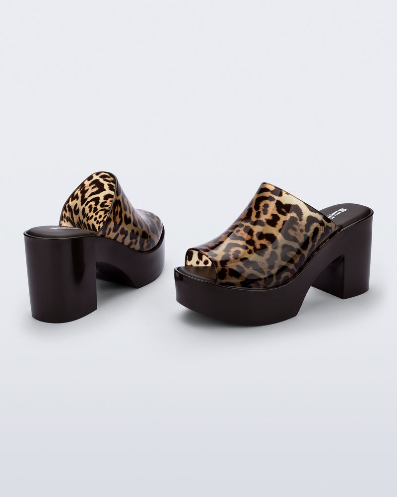 Back and angled view of a pair of black Mule Hype platforms with clear cheetah upper