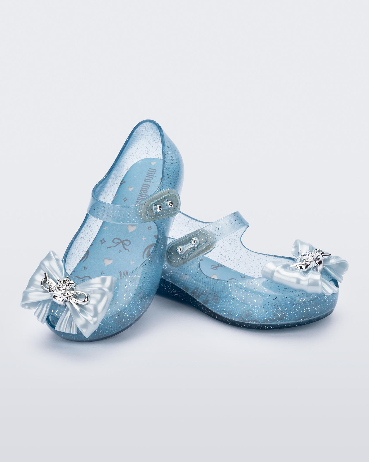 Angled view of a pair of glitter blue Ultragirl Princess ballerina baby flats with bow on top and silver details