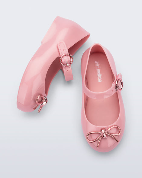 Top and side view of a pair of pink Sweet Love Chrome baby flats with metallic pink bow and buckle