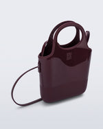 Angled view of a burgundy Ultra Bag with handle and strap