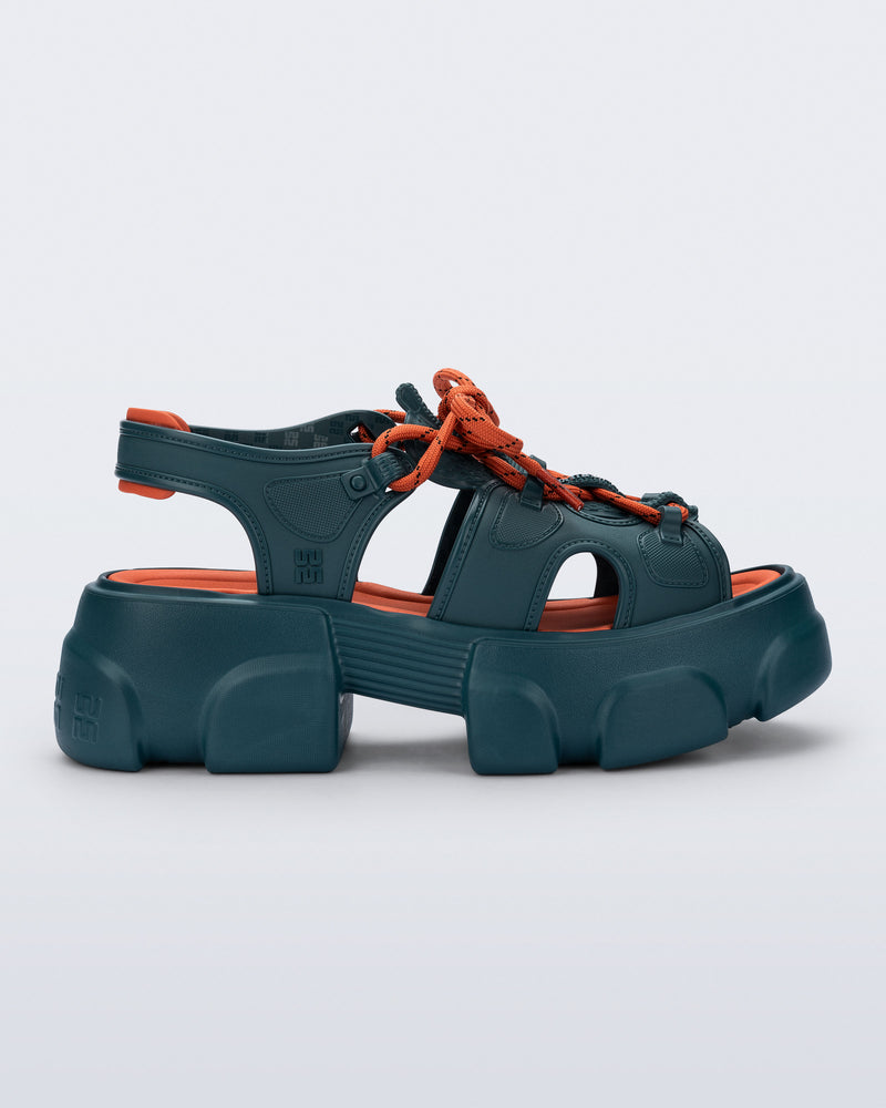 side view of a blue Camp platform sandal with orange laces and accents