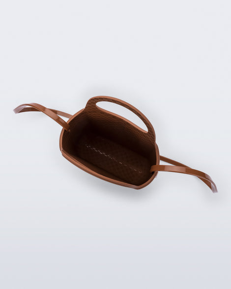 Top view of a light brown Ultra Bag with handle and strap