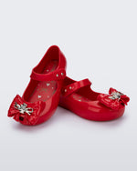 Angled view of a pair of red Ultragirl Princess ballerina baby flats with bow on top and silver details