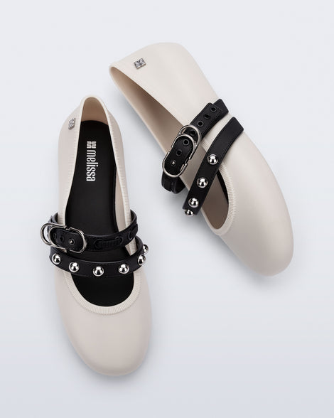 Top and side view of a pair of beige Soft Ballerina Studs flats with black straps and silver embellishments