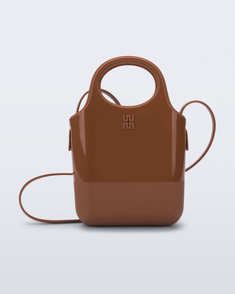 Front view of a light brown Ultra Bag with handle and strap