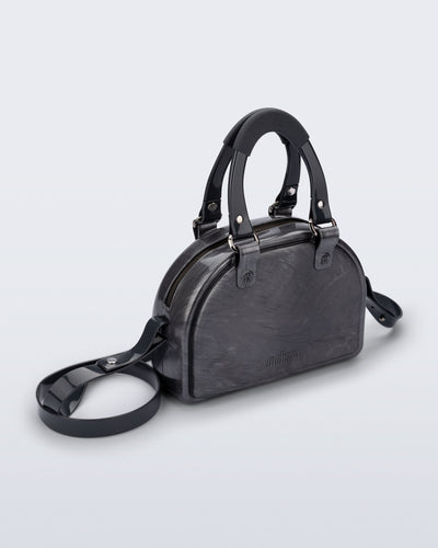 Angled view of a grey Bowling bag with black handle strap and cross body strap
