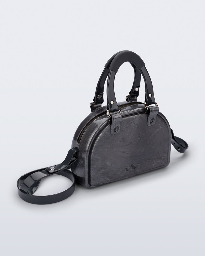 Angled view of a grey Bowling bag with black handle strap and cross body strap