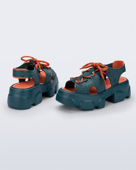 Back and angled view of a pair of blue Camp platform sandals with orange laces and accents
