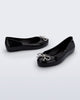 Side and angled view of a pair of black Sweet Love Chrome kids flats with metallic silver bow