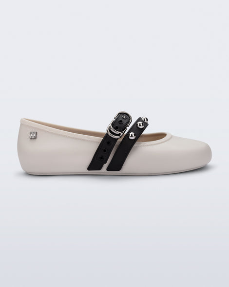 Side view of a beige Soft Ballerina Studs flat with black straps and silver embellishments