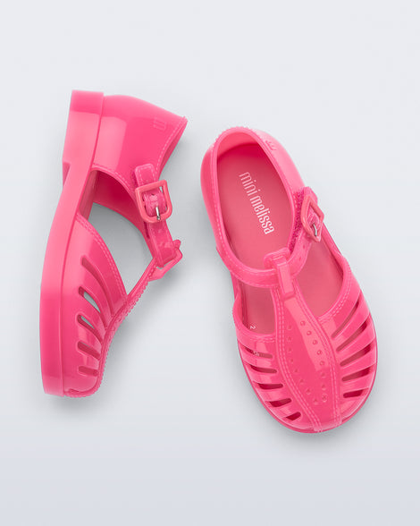 Side and top view of a pair of pink Aranha 79 baby flats with buckle