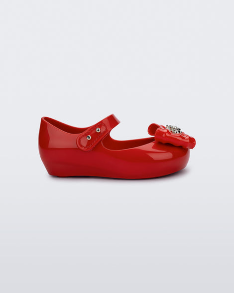 Side view of a red Ultragirl Princess ballerina baby flat with bow on top and silver details