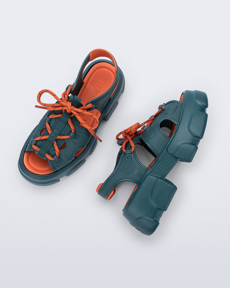 Top and side view of a pair of blue Camp platform sandals with orange laces and accents