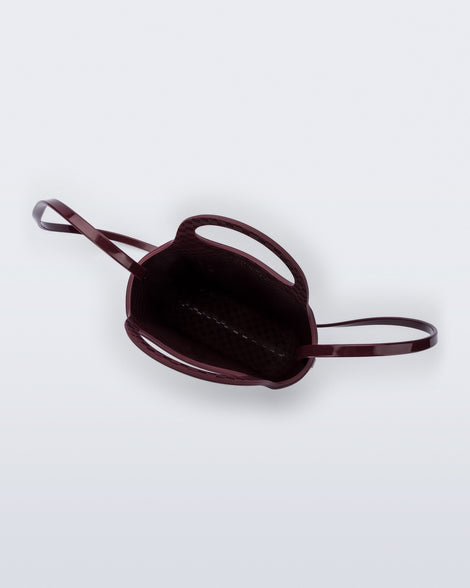 Top view of a burgundy Ultra Bag with handle and strap