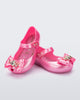 Angled view of a pair of pearly pink Ultragirl Princess ballerina baby flats with bow on top and silver details