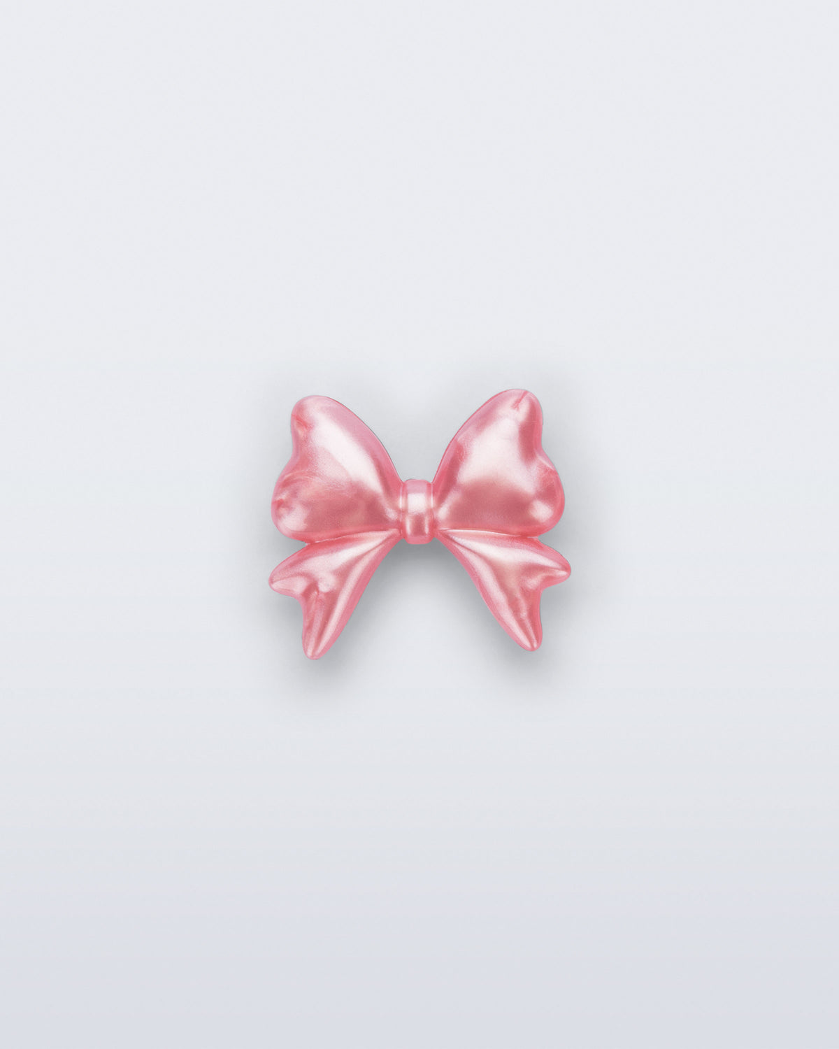 Front view of a pearly pink bow shoe charm