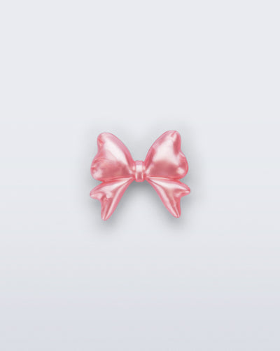 Front view of a pearly pink bow shoe charm