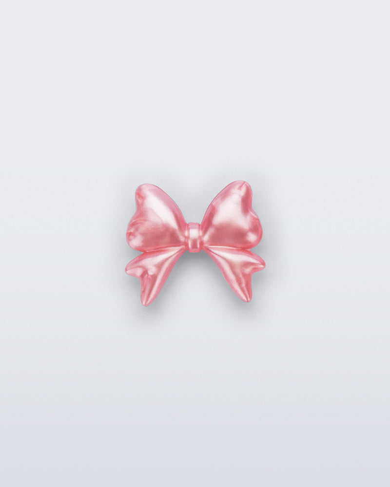Front view of a pearly pink bow shoe charm