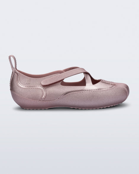 Side view of a pearly pink Aira flat with top straps