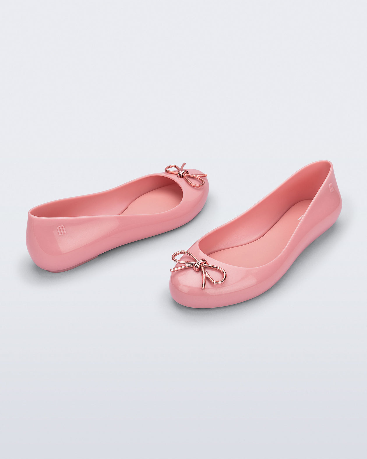 Back and angled view of a pair of pink Sweet Love Chrome flats with metallic pink bow