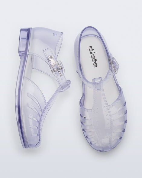 Side and top view of a pair of clear Aranha 79 kids flats with buckle