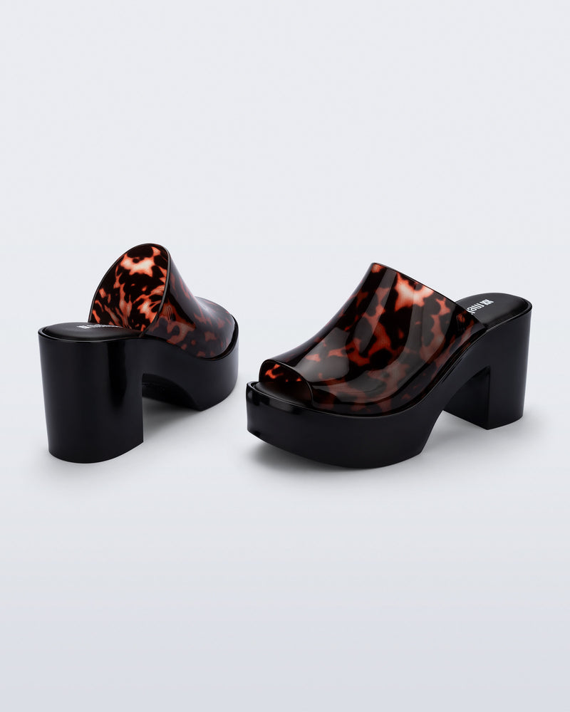 Back and angled view of a pair of black Mule Hype platforms with tortoise upper