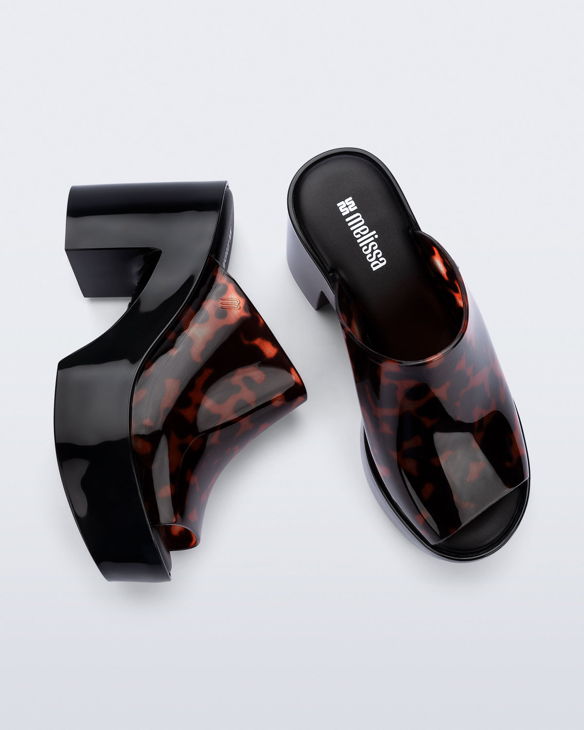 Top and side view of a pair of black Mule Hype platforms with tortoise upper