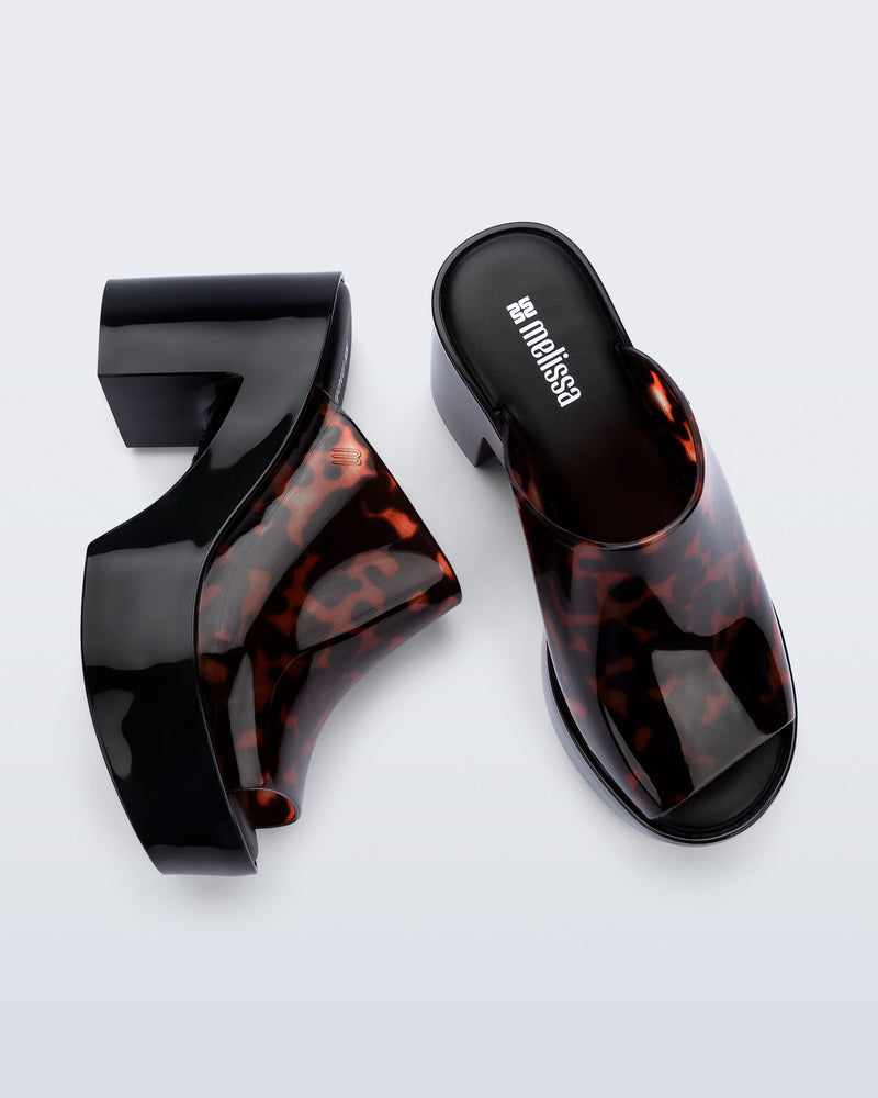Top and side view of a pair of black Mule Hype platforms with tortoise upper