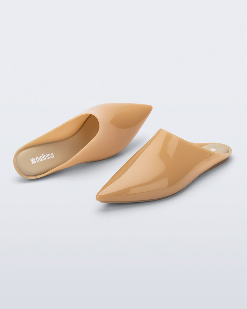 Top and angled view of a pair of milky beige She slip ons with pointed toe