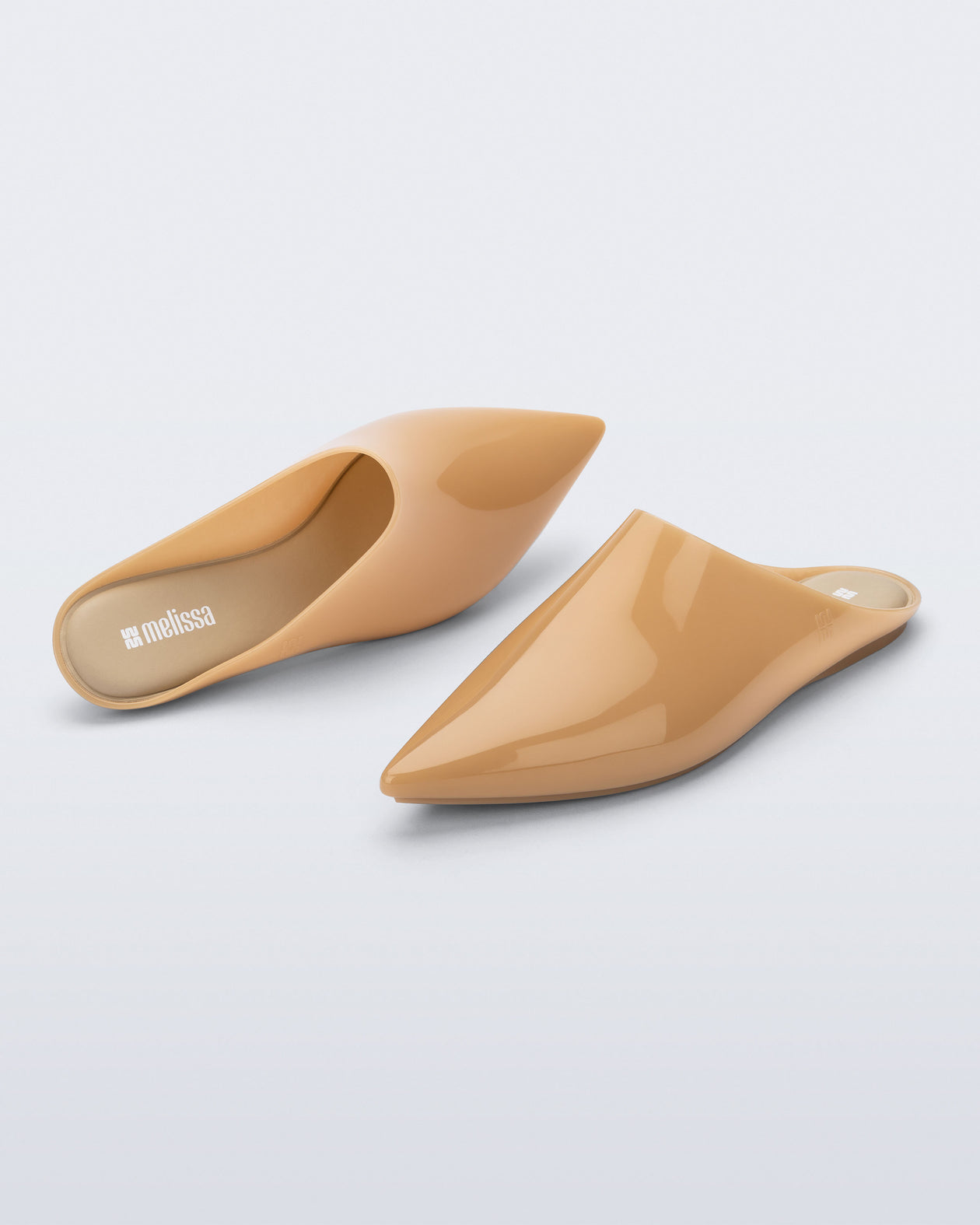 Top and angled view of a pair of milky beige She slip ons with pointed toe