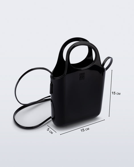 Angled view of a black Ultra Bag with handle and strap with bag dimensions of 15cm x 5cm x 15cm