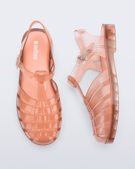 Top and side view of a pair of clear peach Possession fisherman sandals