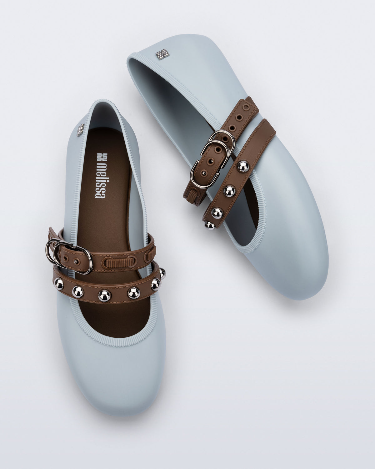 Top and side view of a pair of blue Soft Ballerina Studs flats with brown straps and silver embellishments