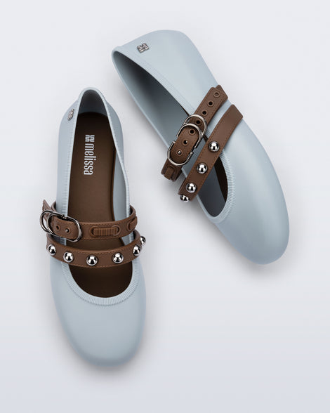 Top and side view of a pair of blue Soft Ballerina Studs flats with brown straps and silver embellishments