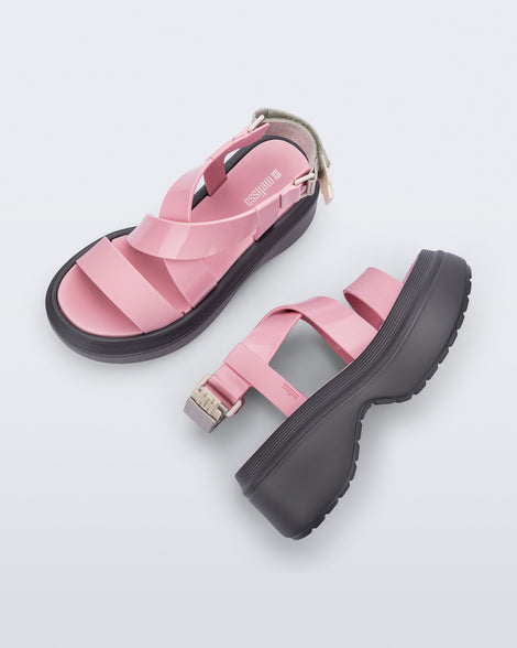 Side and top view of a pair of pink Stand platform sandals with dark grey sole