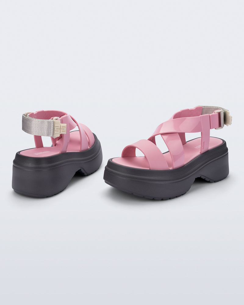 back and angled view of a pair of pink Stand platform sandals with dark grey sole