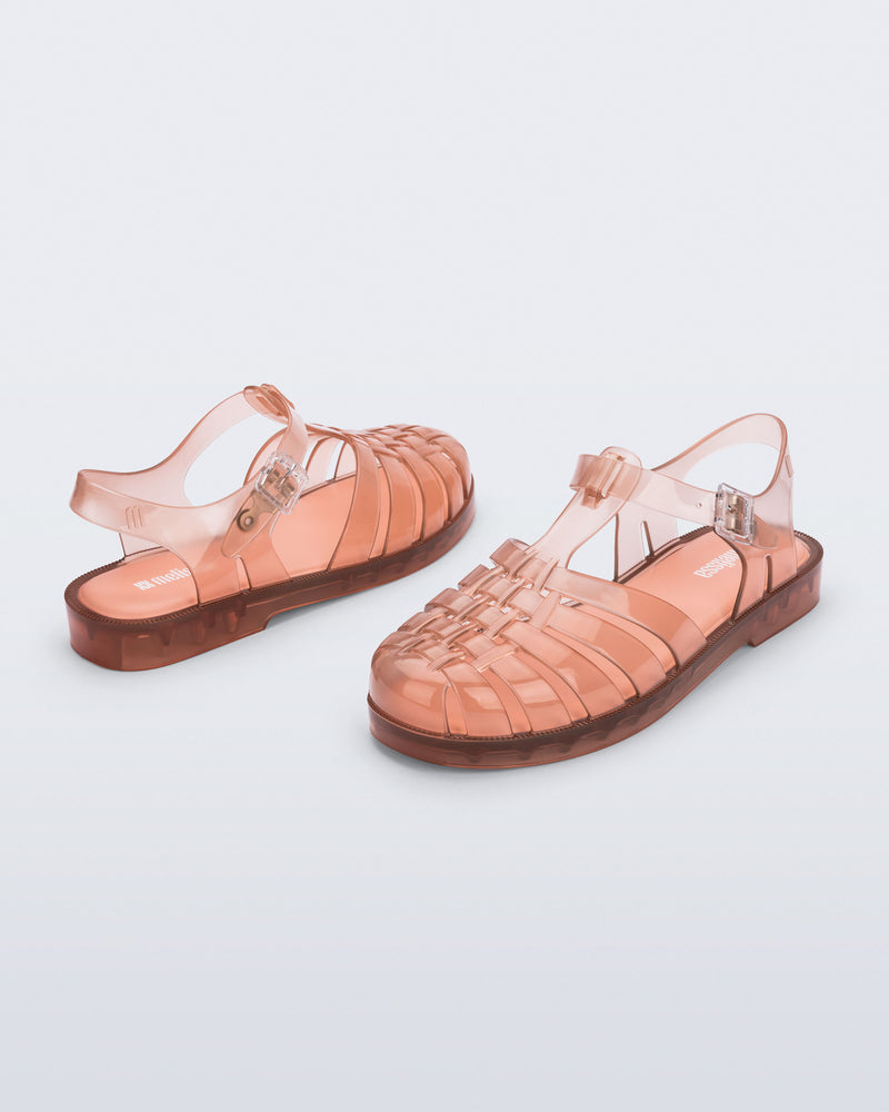 Back and angled view of a pair of clear peach Possession fisherman sandals