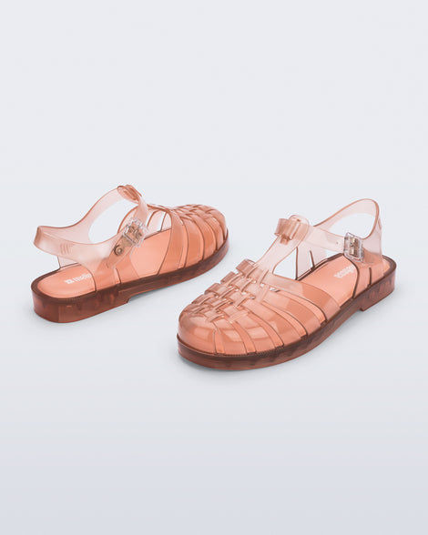 Back and angled view of a pair of clear peach Possession fisherman sandals