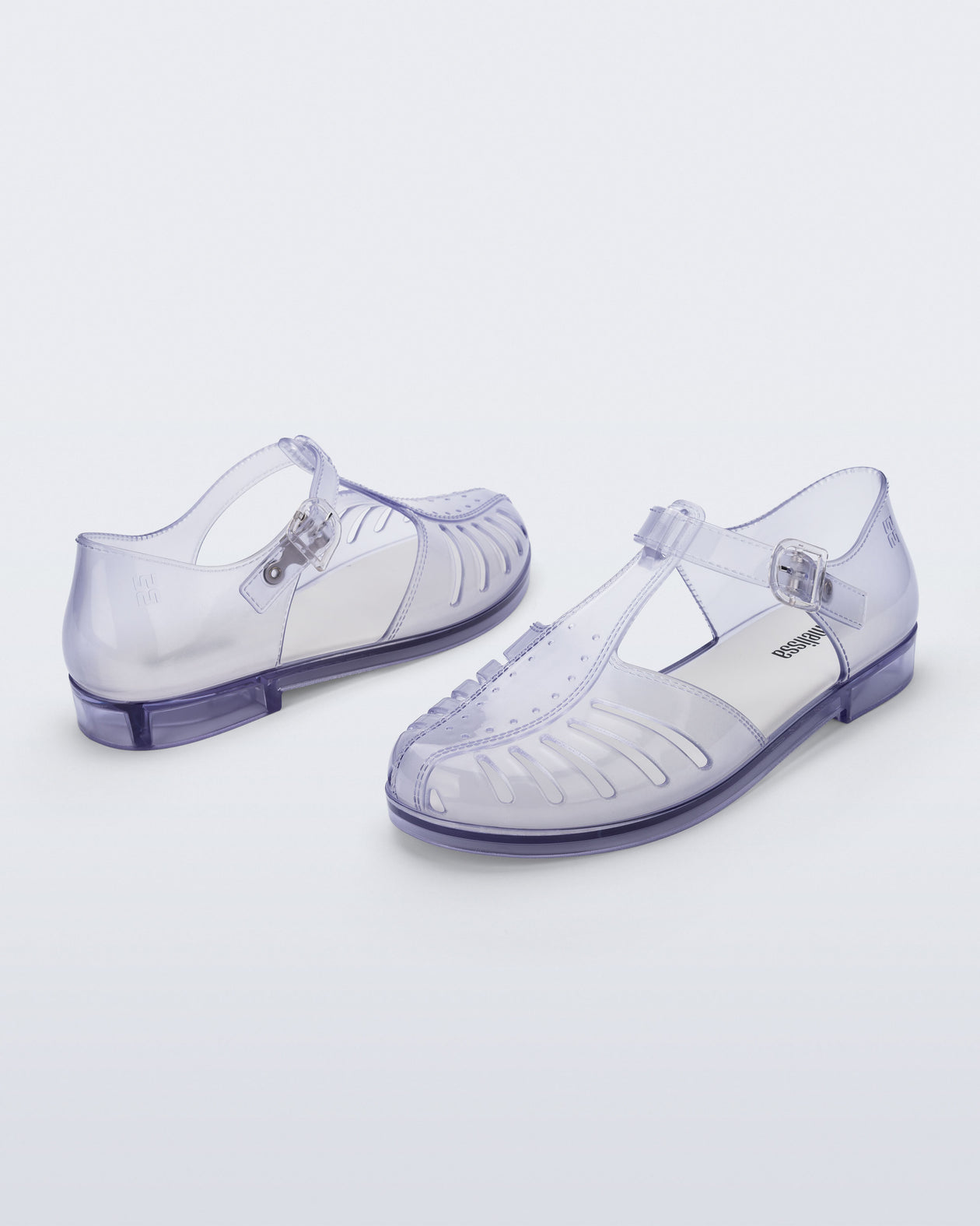 Back and angled view of a pair of clear Aranha 79 flats with buckle