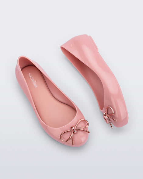 Side and top view of a pair of pink Sweet Love Chrome kids flats with metallic pink bow