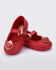 Angled view of a pair of red Soft Ballerina Princess baby flats with a red heart on top