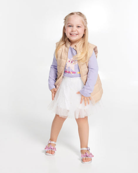 Child model in a white skirt and purple top wearing a pair of pearly white baby Butterfly sandals with butterflies